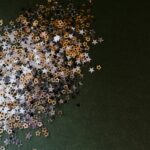 A pile of gold and silver stars on a green surface