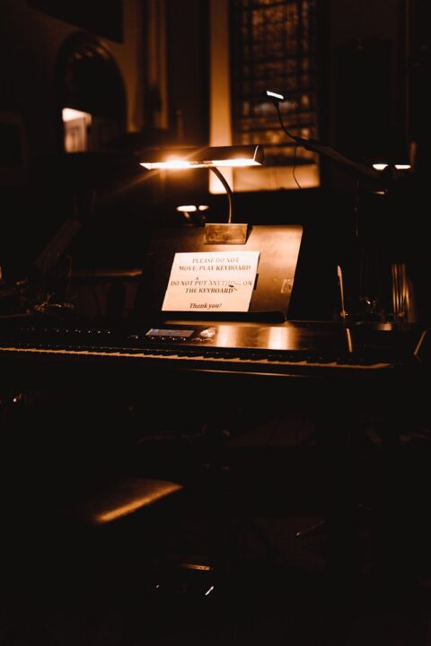 a piano with a note attached to it in a dark room