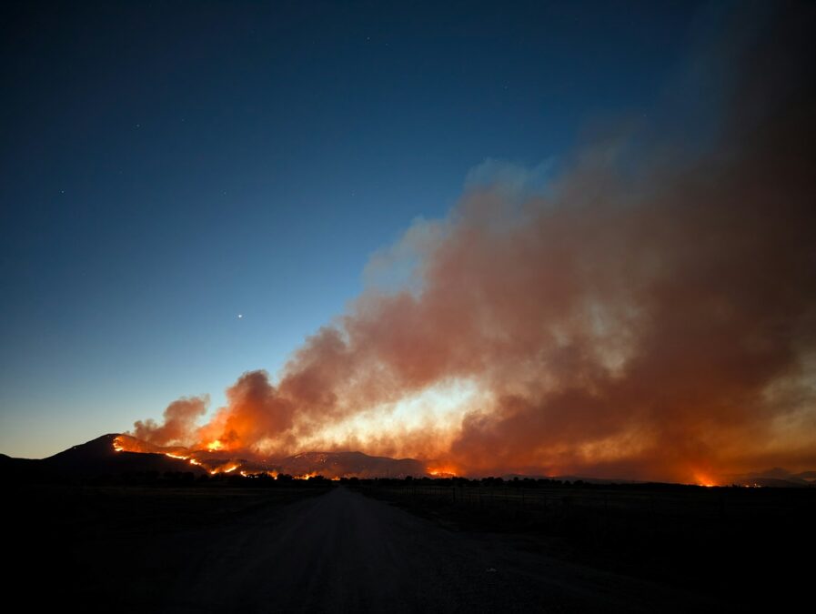 Wildfire burning across a dark landscape at night